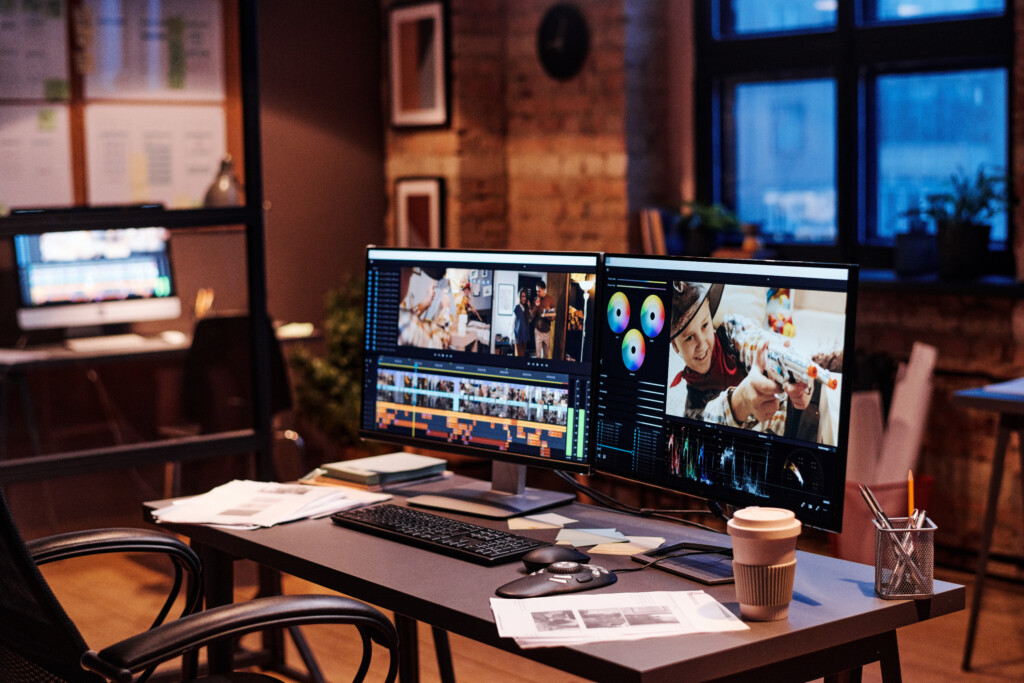 Image of workplace of colorist with computer monitors and documents on table at modern office